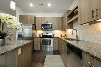 a modern kitchen with stainless steel appliances and granite counter tops